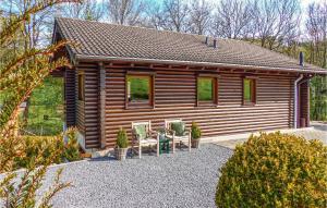 a log cabin with two chairs in front of it at 4 Bedroom Cozy Home In Nimsreuland in Nimsreuland