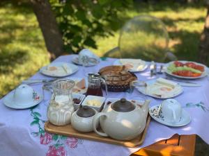 einen Tisch mit Geschirr und Teetöpfen darauf in der Unterkunft Xho's Forest Guest House in Berat