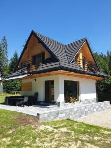 a house with a black roof at Osada Gorce in Nowy Targ