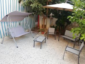 un grupo de sillas, una sombrilla y una mesa en Alle Falde di Erice, en Trapani