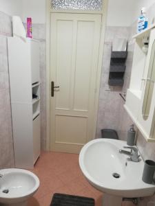 La salle de bains est pourvue d'un lavabo et d'une porte blancs. dans l'établissement Alle Falde di Erice, à Trapani