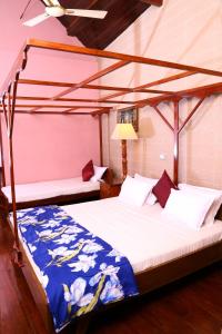 a bedroom with two beds and a lamp at Chiramel Residency in Cochin