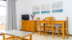 a dining room with a table and a tv at Apartamentos TAMARAGUA in Breña Baja