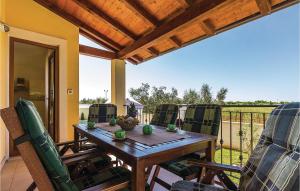 a wooden table and chairs on a porch with a view at 3 Bedroom Nice Home In Liznjan in Ližnjan