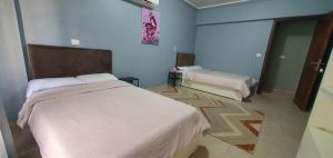 um quarto de hotel com duas camas e um espelho em Tailorbird Nest em Cairo