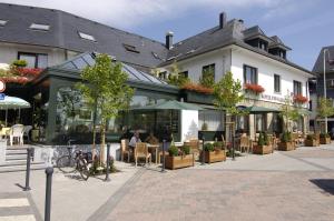 um edifício com mesas e cadeiras em frente a um edifício em Relax-Hotel Pip-Margraff em Sankt Vith