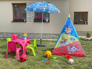 a childs play area with a table and an umbrella at Chalupa pod Tatrami in Liptovská Teplička