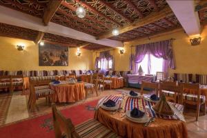 una sala da pranzo con tavoli e sedie di Hotel Kasbah Lamrani a Tinerhir
