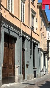 een gebouw met een houten deur op een straat bij Donna Elena - Epoque Residence in Asti