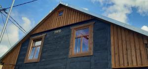 a blue house with two windows on the side of it at Yacht Club in Liepāja