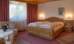 Un dormitorio con una gran cama de madera y una ventana en Landhaus Doris, en Leutasch