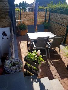 un patio con tavolo, sedie e alcune piante di Eulennest a Elten
