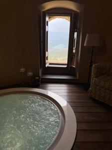 a bath tub in a room with a window at Castello di Rocca Cilento in Rocca Cilento