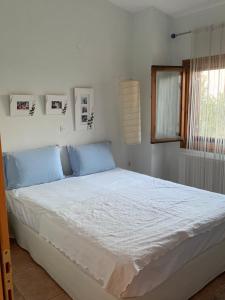 a bedroom with a large bed with blue pillows at ZeusPlace Olympus Olive Country House 2 in Leptokaria