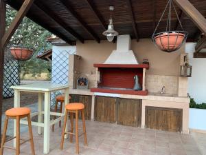 an outdoor kitchen with a stove and stools at ZeusPlace Olympus Olive Country House 2 in Leptokaria