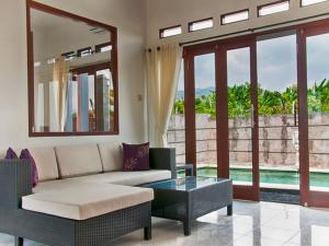 a living room with a couch and a table at Villa Dencarik in Lovina
