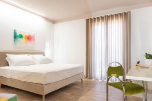 biała sypialnia z łóżkiem i krzesłem w obiekcie Vemaga Luxury Stay in Pompeii w mieście Pompeje