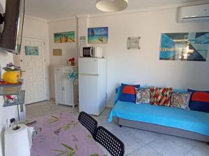 ein Wohnzimmer mit einem blauen Sofa und einem Kühlschrank in der Unterkunft Apartments Llagosta 3 in Denia