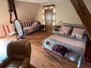 1 dormitorio con 2 camas y sofá en Longère Villariane en Naveil