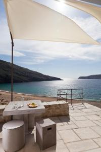 a patio with a table and a view of the ocean at Coco-Mat Eco Residences Serifos in Vayiá
