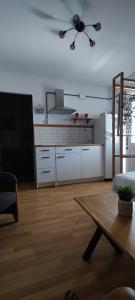 una cocina con armarios blancos y una mesa en una habitación en Apartamento rural, en Alcántara