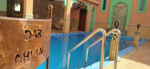 a swimming pool at a hotel with blue water at Dar Ahlam Dades in Aït Ouaddar
