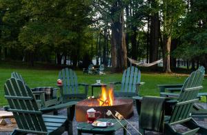 four chairs around a fire pit in a park at Landmark Inn in Cooperstown