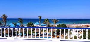 uitzicht op het strand vanaf het balkon van een resort bij Hotel de charme et SPA Dar El Bhar in Mezraya