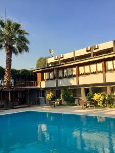 un hotel con piscina frente a un edificio en Artemis Yörük Otel Pamukkale en Pamukkale