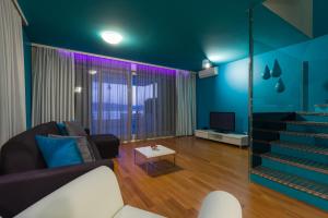 a living room with a couch and a tv at Apartments Villa Azzurra Bol in Bol