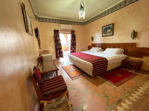 廷吉尔Hotel Kasbah Lamrani的卧室里有一张床和一把椅子 更多37张照片
