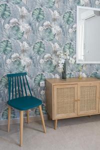a room with a chair and a mirror and a dresser at Apartment Patricia in Zakynthos Town