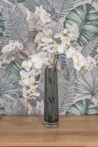 Eine Vase mit weißen Blumen auf einem Tisch in der Unterkunft Apartment Patricia in Zakynthos