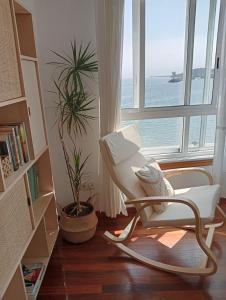 une chaise blanche assise dans une pièce avec fenêtre dans l'établissement Pura Playa - Rías Baixas - Galicia, à Cangas