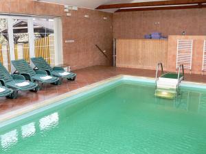 a swimming pool with green chairs and a swimming pool at Vinařský dvůr in Valtice