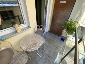 a balcony with a table and chairs and a window at Apartsee Zell am See in Zell am See