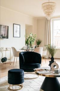un soggiorno con tavolo, divano e sedie di Bogoria Residence - LoftAffair Collection a Cracovia
