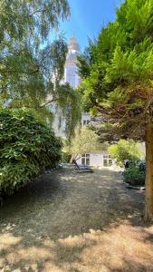 een park met een gebouw op de achtergrond met bomen bij Au jardin de la Basilique in Boulogne-sur-Mer