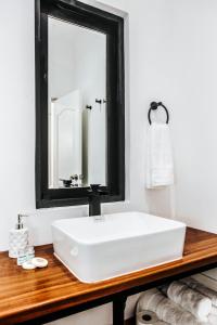 La salle de bains est pourvue d'un lavabo blanc et d'un miroir. dans l'établissement WasiPai Boutique Hotel, à Lima