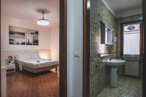 a bedroom with a bed and a bathroom with a sink at Venice Vacation House in Mestre