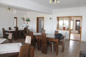 a dining room with wooden tables and chairs at Pensiunea Muntele Alb in Horezu