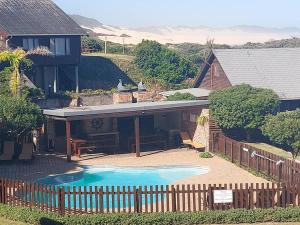 a house with a swimming pool next to a fence at PA Sands Beach House Kowie River 9 Sleeper Pool in Port Alfred