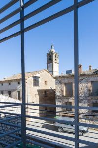 - une vue depuis la fenêtre d'un bâtiment avec une tour d'horloge dans l'établissement Enlakruz, à Lagartera