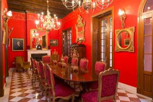 a dining room with a red table and chairs at Hotel Ateneo Sevilla in Seville