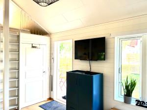 a screened in porch with a tv and a black cabinet at Bittes & Lasses Guest House in Kalmar