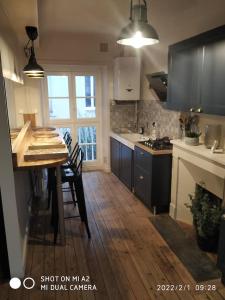 a kitchen with a wooden table and a counter top at SAMANDINE HOME in Bayeux