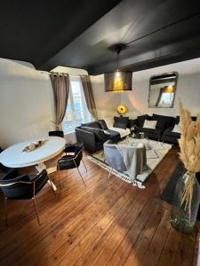 a living room with a couch and a table and chairs at SAMANDINE HOME in Bayeux