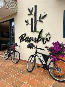 zwei Fahrräder, die vor einem Gebäude mit einem Schild geparkt sind in der Unterkunft Ayenda Hotel Bambu Guatape in Guatapé