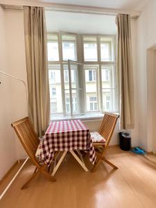 uma mesa e duas cadeiras num quarto com uma janela em City Apartment and rooms em Viena