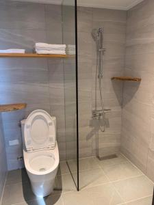a bathroom with a toilet with a glass shower stall at Drizzle Tea House in Fenchihu